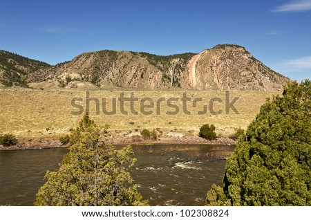 Devil\'s Slide is layers of rock that have been raised and tilted by faulting in the earth\'s surface. The Yellowstone River is in the foreground.