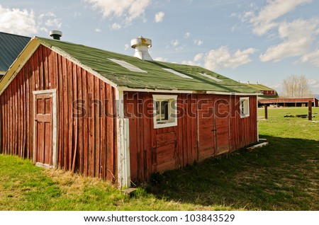 Red barns with white trim and green roofs on a ranch
