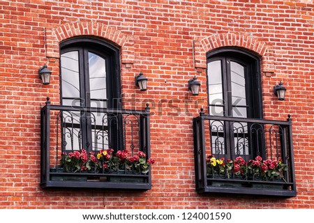 French doors with wrought iron balconies and flower boxes on  the side of a  hotel that was built in 1881 in Montana