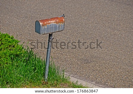Rusty, old mailbox sitting at the curb waiting for the mail as it has done for many years