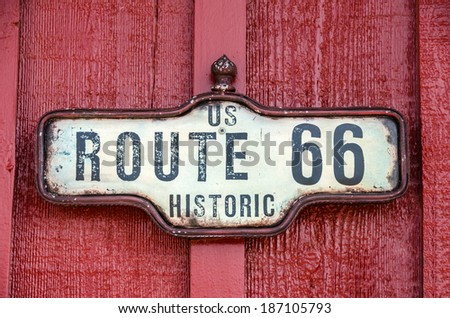 Framed sign for historic US Route 66 on a red building