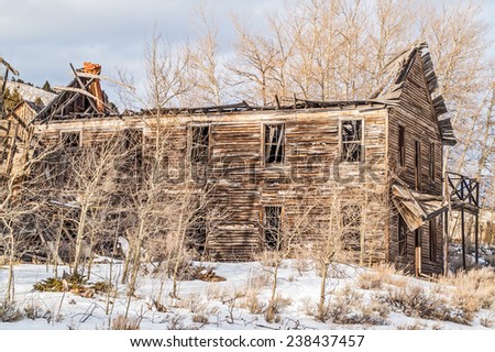 What is left of an old hotel in a Montana ghost town is being hidden by aspen trees.