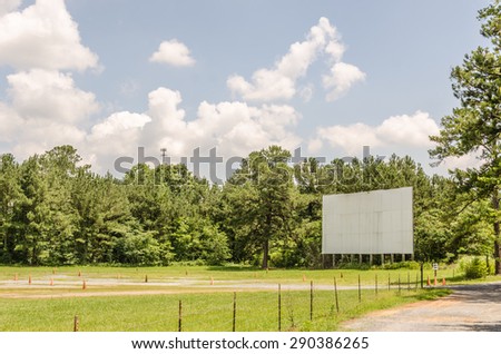 Drive-in theater movie screen that looks quite lonely without the speakers