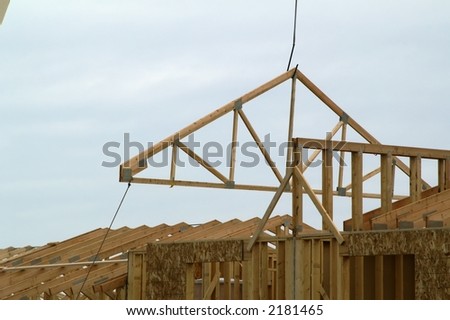 Swinging roof truss into place on new building