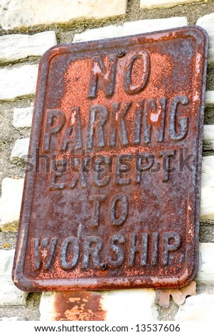 Rusty sign that says no parking except to worship found on abandoned church