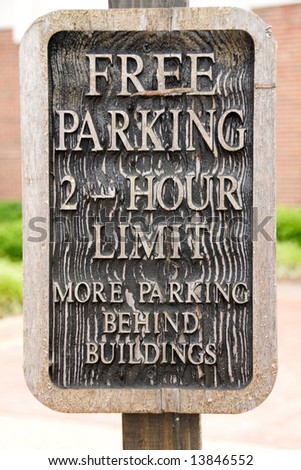 Somewhat weathered free parking sign made from wood