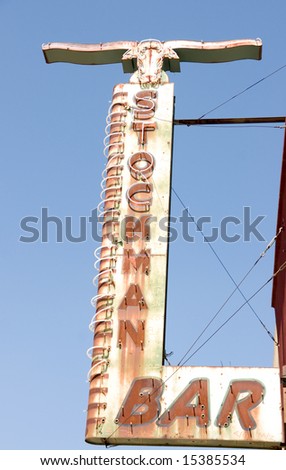 Rusty, weathered sign for stockman bar with brands along the side