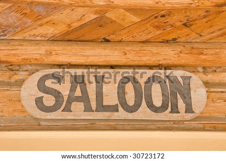 Saloon sign with letters on wood hanging in a ghost town