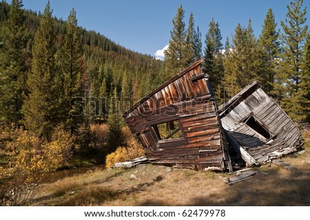 Long-abandoned home or bunkhouse has been left to fall apart through vandalism, weather, time, and cows in the Montana ghost town of Coolidge