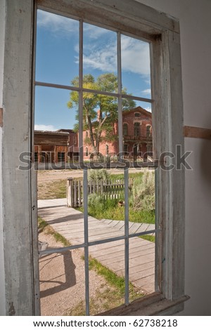 Old, multi-paned window gives a distorted, warped, or blurred view of the world looking through the old, thick glass
