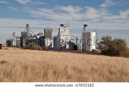 Grain elevators sitting next to a railroad track in rural America