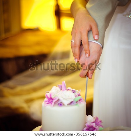 Couple cutting wedding cake with a knife
