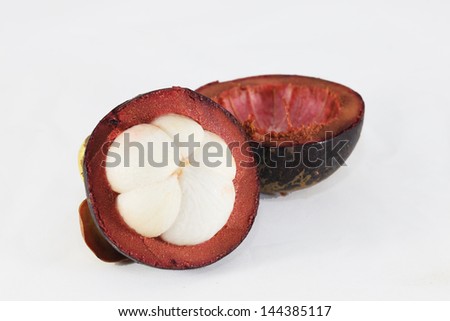 Mangosteen and cross section showing the thick purple skin and white flesh of the queen of friuts.