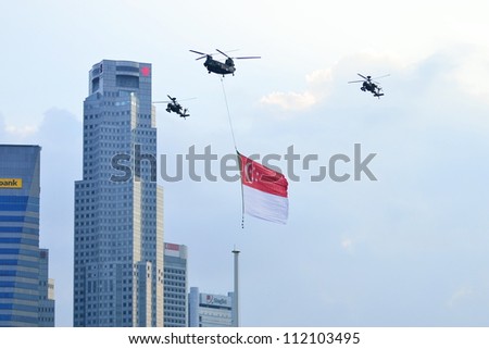 SINGAPORE - AUGUST 9: Chinook flypast with Singapore national flag above The Float Marina Bay from Marina Bay Sands during National Day Parade Singapore 2012 on August 9, 2012 in Singapore.