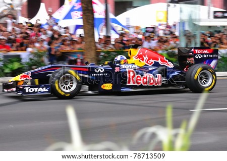 SINGAPORE - APRIL 24: David Coulthard, racing down the lanes in Redbull Racing Car on the streets of Orchard Road in Red Bull Speed Street Singapore on April 24, 2011 in Singapore.
