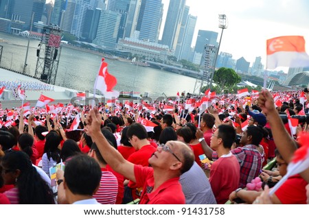 SINGAPORE - AUGUST 9: Audience wave flags during National Day Parade Singapore 2011 August 09, 2011 in Singapore.