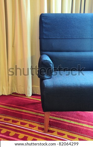 old single sofa seat in front of a curtain