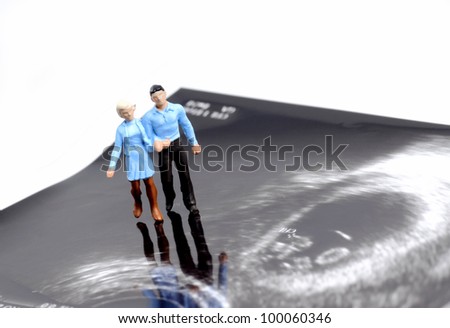 tiny figure of couple walking on early pregnancy ultrasound image