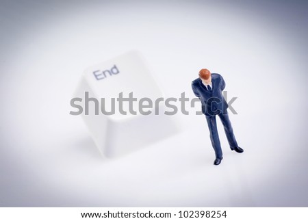 tiny figure of businessman stands in front of end key