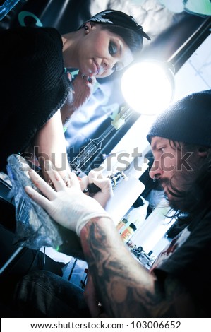 WARSAW - NOV 12: Tattooist makes a tattoo on his client\'s hand during the tattoo, body painting and pierceing show \'Body Art Convention\' on 12th November, 2011 in Warsaw