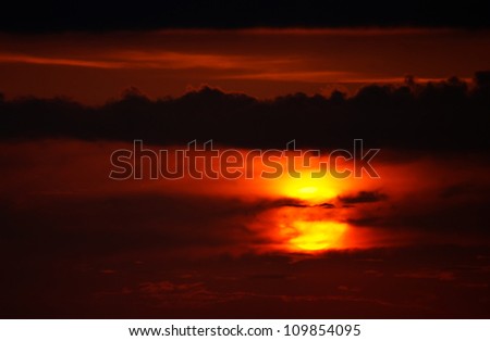 Close up on sun covered by clouds during lovely sunset on Corfu Island, Greece
