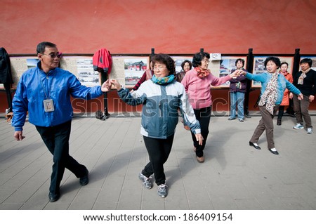 BEIJING, CHINA - MARCH 28: Chinese man gives a dance lesson for a group of women in Jingshan Park on March 28, 2013 in Beijing