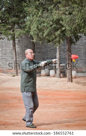BEIJING, CHINA - MARCH 28: Chinese man plays diabolo in Jingshan Park on March 28, 2013 in Beijing