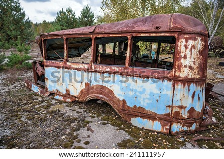 rusty bus on junk yard near Illinci village in Chernobyl Nuclear Power Plant Zone of Alienation, Ukraine