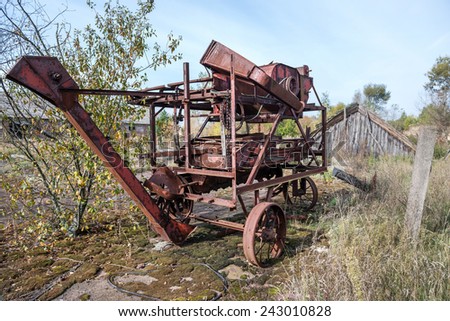 old thrashing machine in kolkhoz near Korohod village in Chernobyl Nuclear Power Plant Zone of Alienation, Ukraine