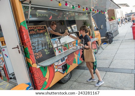 WARSAW, POLAND - AUGUST 2: Woman buys Mexican food during Food Truck festival on August 2, 2014 in Warsaw