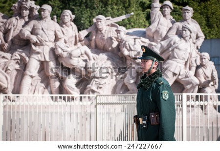 BEIJING, CHINA - MARCH 27: Chinese soldier stands on attention in front of revolutionary statu next to Mausoleum of Mao Zedong at Tiananmen Square on March 27, 2013 in Beijing