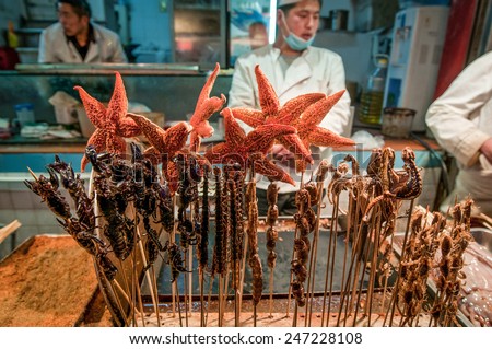 BEIJING, CHINA - MARCH 26: food stall serving exotic food such starfishes, sea horses or fried scorpions and bugs at Wangfujing Snack Street on March 26, 2013 in Dongcheng District, Beijing