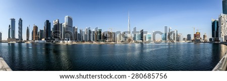 Panoramic view of business bay and downtown area of Dubai reflection in a river.