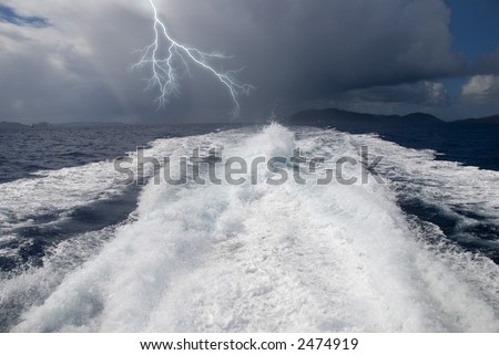 The wake from a high-speed boat as it heads away from a storm.