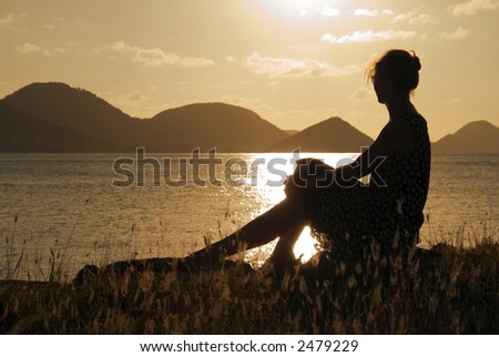 A woman watching the sunset in the Caribbean.