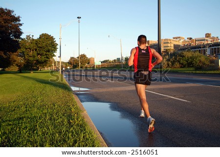 A solitary marathon runner sets the pace during the opening stages of a race.
