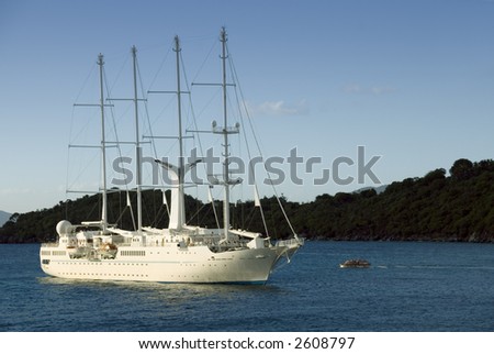 A wind-powered cruise ship anchored in the Caribbean near dusk.