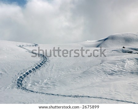 A single trail of footprints in deep snow.
