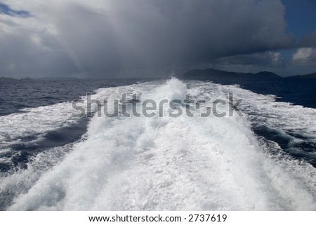 The wake from a high-speed boat as it heads away from a storm.