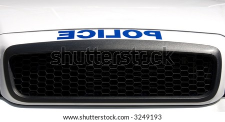 A reversed police sign above the grille of a North American cruiser.