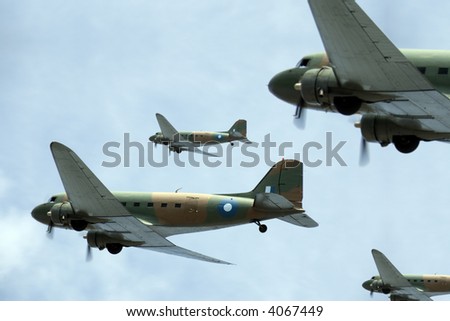 A flight of Dakota (Douglas C-47) transport planes banking to starboard. (Created with minimum depth of field. Focus is on the second aircraft from the front.)