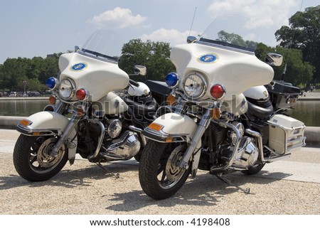 Two Secret Service motorcycles stand near the Reflecting Pool on The Mall in Washington, DC.