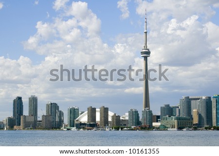 Downtown Toronto - including the Rogers Centre, CN Tower, and Harbourfront Centre - on a partly cloudy summer day.