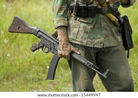 A world war two German soldier holding a submachine gun. Shot with minimum depth of field. Focus is on the hand and gun.