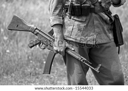 A world war two German soldier holding an MP43 submachine gun. Shot with minimum depth of field. Focus is on the hand and gun.