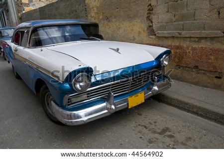A blue and white 1950s American car still running on the streets of Cuba.