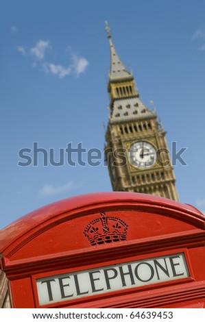 The clock tower of the Palace of Westminster in London, UK behind a classic red telephone box. It is commonly referred to as Big Ben although this is the nickname for the great bell.
