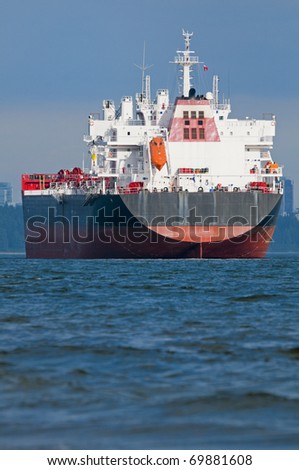 An empty cargo ship anchored just outside a port.