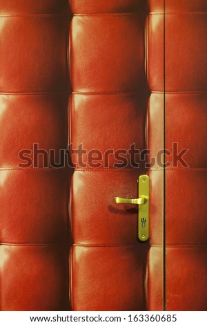 A quilted red leather door and golden handle
