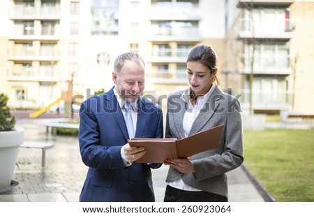 Two business people standing and discussingin front of the office